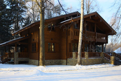 На фото: двухэтажный, деревянный, коричневый дом в стиле кантри с
