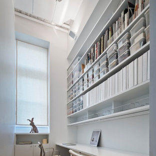 Design ideas for a small modern study in New York with white walls, light hardwood flooring, a built-in desk and beige floors.