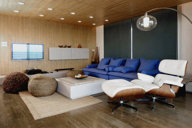 Large mid-century modern enclosed medium tone wood floor family room photo in New York with white walls, no fireplace and a wall-mounted tv