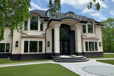 Example of a multicolored stucco house exterior design in New York with a hip roof, a shingle roof and a black roof
