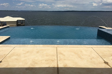 Mid-sized transitional backyard concrete and custom-shaped infinity hot tub photo in Austin