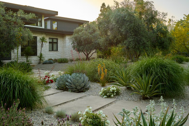 Photo of a southwestern drought-tolerant and desert front yard concrete paver and metal fence landscaping in Sacramento for summer.