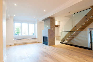 Living room - large contemporary open concept light wood floor living room idea in Toronto with a standard fireplace and a stone fireplace