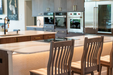 Transitional kitchen photo in Orlando with flat-panel cabinets, dark wood cabinets and two islands