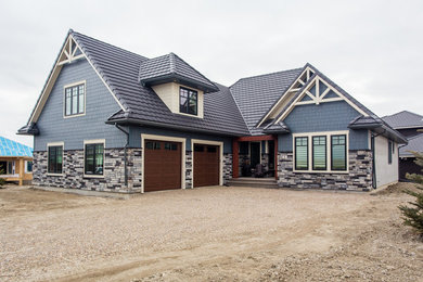 Large arts and crafts split-level blue exterior in Calgary with mixed siding and a gable roof.