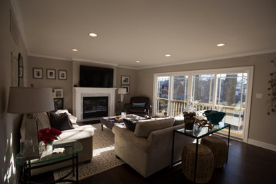 Family room - mid-sized transitional enclosed dark wood floor and brown floor family room idea in Philadelphia with beige walls, a standard fireplace, a stone fireplace and a wall-mounted tv