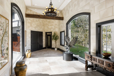 Example of a huge french country ceramic tile, beige floor, coffered ceiling and brick wall entryway design in Vancouver with beige walls and a black front door