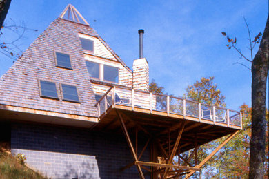 Ejemplo de fachada de casa minimalista de tamaño medio con revestimiento de madera y teja