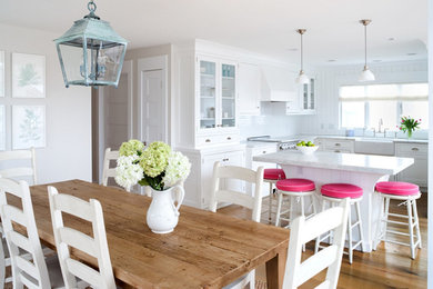Mid-sized arts and crafts u-shaped light wood floor open concept kitchen photo in Salt Lake City with a farmhouse sink, shaker cabinets, white cabinets, marble countertops, white backsplash, stone tile backsplash, white appliances and an island