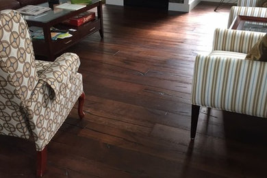 Inspiration for a large timeless enclosed dark wood floor and brown floor living room remodel in Cleveland with gray walls, a standard fireplace, a stone fireplace and a wall-mounted tv