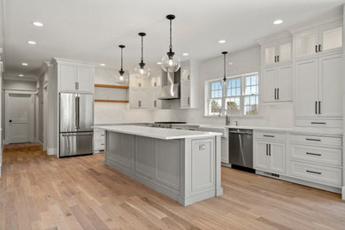 Inspiration for a modern l-shaped light wood floor eat-in kitchen remodel with a farmhouse sink, beaded inset cabinets, quartzite countertops, stainless steel appliances, an island and white countertops
