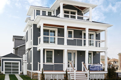 Example of a mid-sized beach style gray three-story concrete fiberboard house exterior design in Philadelphia with a hip roof and a shingle roof
