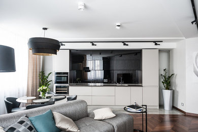 Design ideas for a contemporary single-wall open plan kitchen in Other with a single-bowl sink, flat-panel cabinets, black splashback, glass sheet splashback, stainless steel appliances and no island.