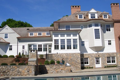 This is an example of an expansive traditional three-storey grey exterior in New York with stone veneer.