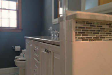 This is an example of a small traditional kids bathroom in Philadelphia with recessed-panel cabinets, white cabinets, granite benchtops, multi-coloured tile, glass tile, an undermount sink and blue walls.