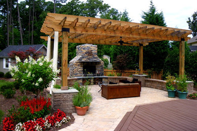 Patio - large rustic backyard concrete paver patio idea in Other with a fire pit and a pergola