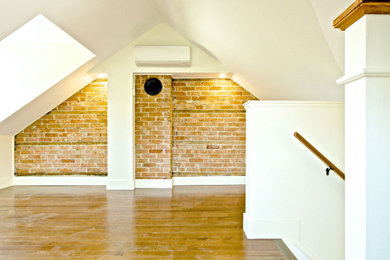 Small arts and crafts freestanding desk medium tone wood floor, brown floor and brick wall home studio photo in Toronto with white walls