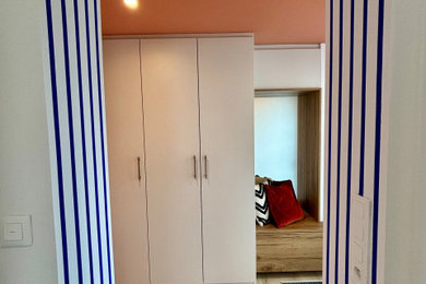 Inspiration pour un hall d'entrée design avec un mur orange, sol en stratifié et un sol beige.