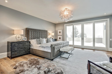 This is an example of a contemporary master bedroom in Calgary with grey walls, medium hardwood floors and beige floor.