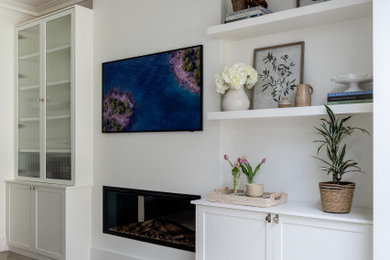 This is an example of a medium sized classic formal open plan living room in London with white walls, porcelain flooring, a standard fireplace, a plastered fireplace surround, a concealed tv, beige floors and a chimney breast.