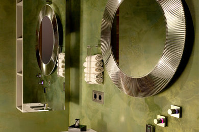 Modernes Badezimmer mit flächenbündigen Schrankfronten, grauen Schränken, grüner Wandfarbe und integriertem Waschbecken in München