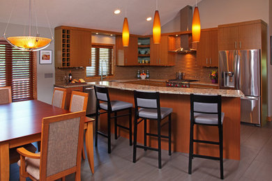 Mid-sized trendy u-shaped porcelain tile and gray floor eat-in kitchen photo in Minneapolis with an undermount sink, flat-panel cabinets, light wood cabinets, granite countertops, brown backsplash, ceramic backsplash, stainless steel appliances and a peninsula