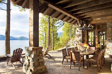 Patio - mid-sized southwestern backyard brick patio idea in Other with a roof extension