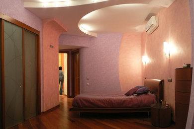 На фото: хозяйская спальня среднего размера в стиле модернизм с разноцветными стенами и паркетным полом среднего тона с