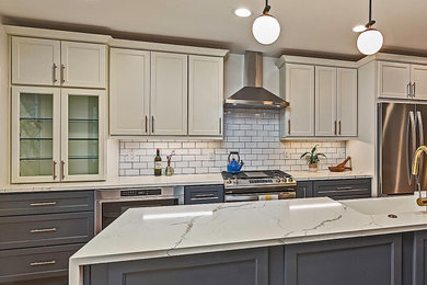 Example of a large cottage single-wall medium tone wood floor and brown floor eat-in kitchen design in Seattle with a farmhouse sink, shaker cabinets, black cabinets, quartz countertops, white backsplash, ceramic backsplash, stainless steel appliances, an island and white countertops
