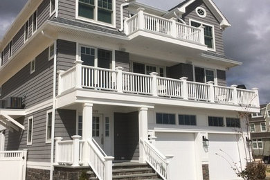 Photo of a large beach style three-storey grey exterior in Other with mixed siding.