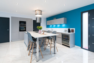Réalisation d'une très grande cuisine ouverte encastrable minimaliste en L avec un évier intégré, un placard à porte affleurante, des portes de placard grises, un plan de travail en quartz, une crédence blanche, une crédence en quartz modifié, un sol en carrelage de céramique, îlot, un sol blanc et un plan de travail blanc.