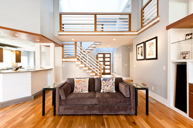 Example of a large trendy open concept and formal medium tone wood floor and brown floor living room design in Atlanta with gray walls, a two-sided fireplace, a media wall and a tile fireplace