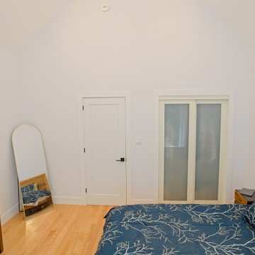 Vaulted Bedroom with Low Storage Door and Frosted Closet Panels | East York