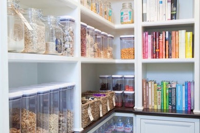 Design ideas for a medium sized traditional l-shaped kitchen pantry in London with dark hardwood flooring, black floors, recessed-panel cabinets and brown worktops.