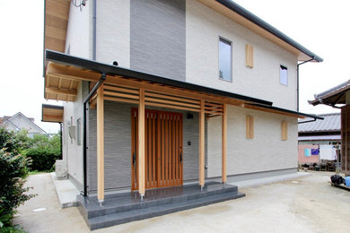 Imagen de fachada de casa beige y gris grande de dos plantas con revestimientos combinados, tejado a dos aguas y tejado de teja de barro
