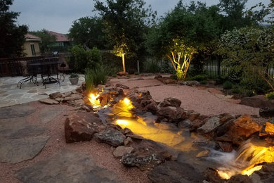 Photo of a mid-sized traditional full sun backyard gravel landscaping in Austin.