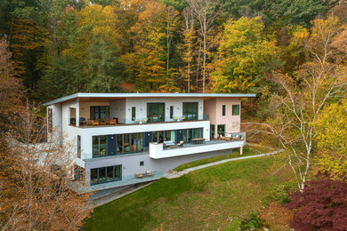 Example of a mid-sized 1950s white two-story exterior home design in New York with a metal roof and a white roof