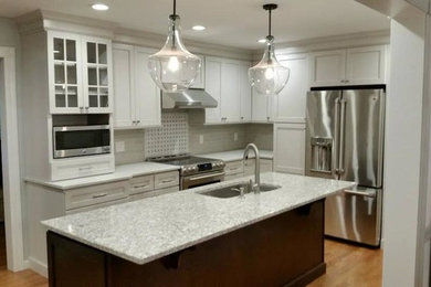 Kitchen - mid-sized transitional kitchen idea in New York with white cabinets and an island