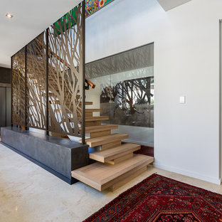 Exempel på en stor eklektisk foajé, med vita väggar, kalkstensgolv, en pivotdörr, mellanmörk trädörr och beiget golv