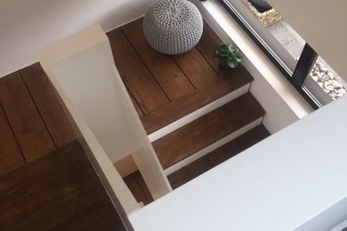 Imagen de escalera en U actual de tamaño medio con escalones de madera, contrahuellas de madera y barandilla de varios materiales
