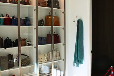 Inspiration for a large modern women's light wood floor dressing room remodel in San Francisco with glass-front cabinets and white cabinets