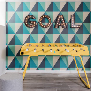 Immagine di un piccolo soggiorno design aperto con sala giochi, pavimento con piastrelle in ceramica, nessun camino, TV a parete, pavimento grigio e pareti multicolore