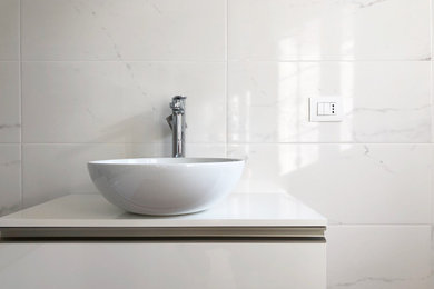 Esempio di una parquet e piastrelle stanza da bagno moderna con ante lisce, ante bianche, WC a due pezzi, piastrelle in gres porcellanato, un lavabo e mobile bagno sospeso