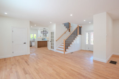 Large trendy light wood floor foyer photo in Other with white walls