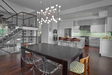 Expansive contemporary kitchen/dining combo in Edmonton with white walls, dark hardwood floors and no fireplace.