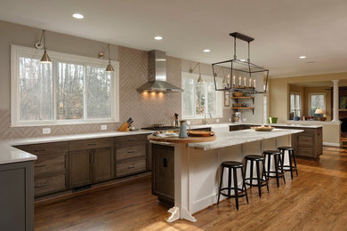 Inspiration for a large transitional u-shaped eat-in kitchen in DC Metro with a farmhouse sink, shaker cabinets, medium wood cabinets, quartz benchtops, beige splashback, subway tile splashback, stainless steel appliances, light hardwood floors and with island.