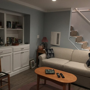 ボストンの中サイズのトラディショナルスタイルのおしゃれな地下室 (全地下、グレーの壁、濃色無垢フローリング、標準型暖炉、木材の暖炉まわり、茶色い床) の写真