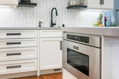Inspiration for a mid-sized transitional u-shaped eat-in kitchen remodel in San Francisco with shaker cabinets, white cabinets, quartz countertops, white backsplash, marble backsplash, an island and gray countertops