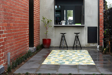 Photo of a small contemporary side yard partial sun outdoor sport court in Melbourne with natural stone pavers.