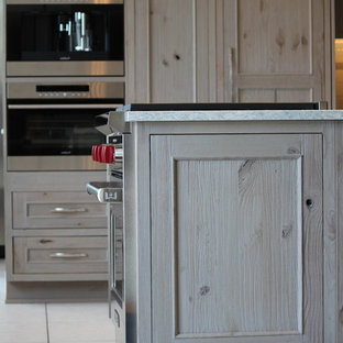 Mid-sized beach style kitchen pantry inspiration - Inspiration for a mid-sized beach style u-shaped ceramic floor kitchen pantry remodel in Grand Rapids with an undermount sink, recessed-panel cabinets, distressed cabinets, quartz countertops, blue backsplash, mosaic tile backsplash, stainless steel appliances and a peninsula